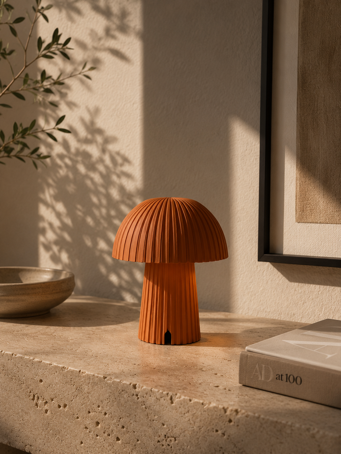 Little Mush Terracotta table lamp glowing on a bedside table.