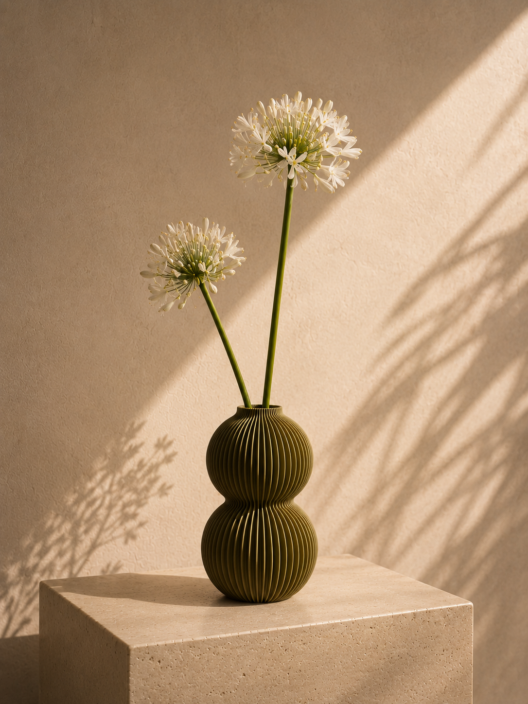 Olive ribbed Orb vase on a concrete pedestal.